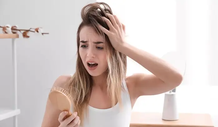 دختری در حال درد کشیدن در ریشه مو هنگام شانه زدن